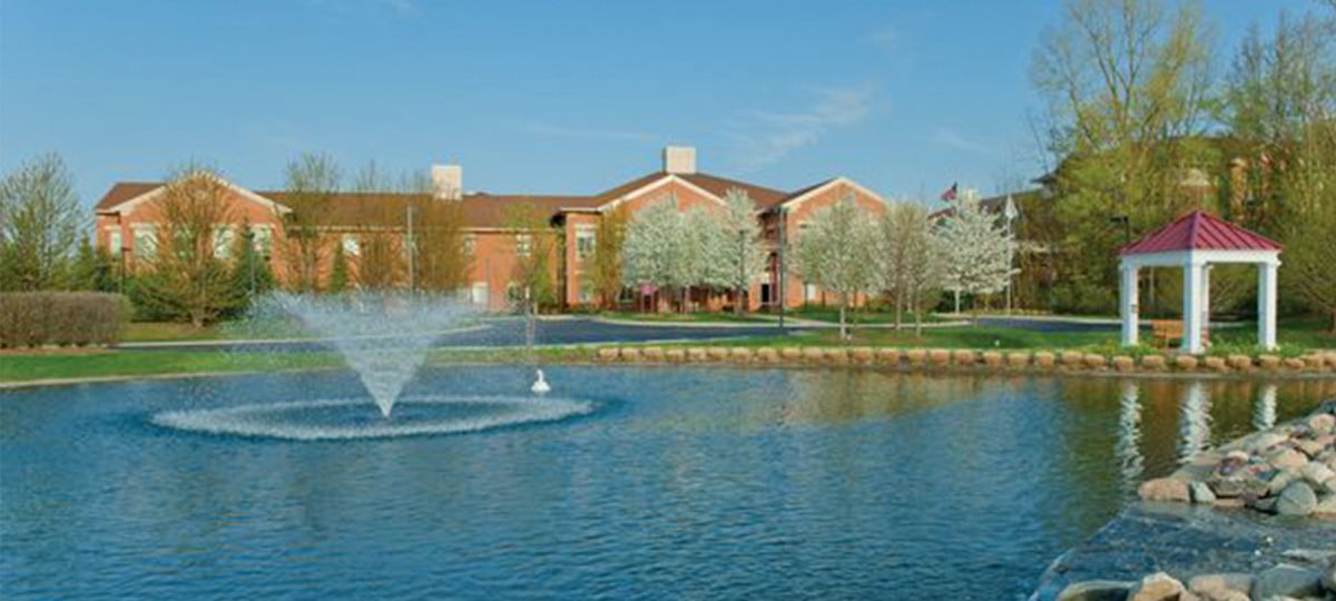 Fountain in pond outside of community building.