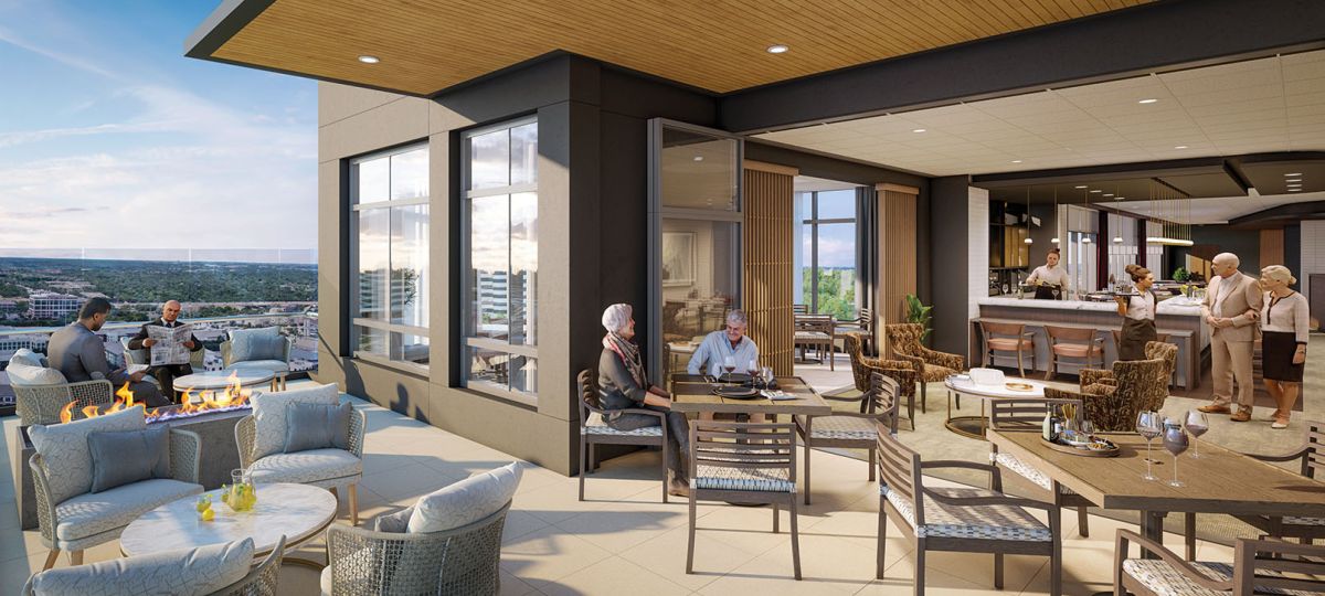 Conceptual rendering of a rooftop terrace with outdoor seating and fire pit overlooking the city. Residents enjoy drinks and conversation at tables, while others socialize near an indoor bar area. Modern furniture and a wooden ceiling create a warm, inviting atmosphere.