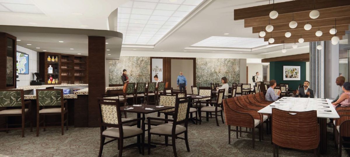 Upscale community bar and dining area with high-top seating, wood accents, pendant lighting, and residents socializing at tables.