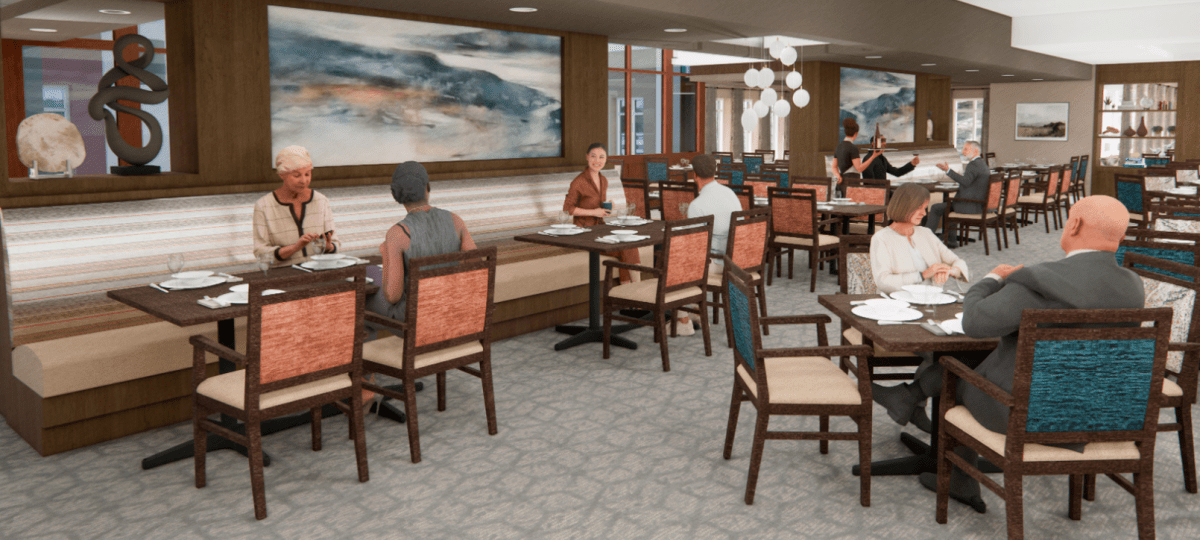 Spacious senior living dining room with multiple tables, cushioned chairs, wall art, and residents enjoying a meal.