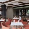 Interior rendering of an Erickson Senior Living community dining and bar area with tables, lounge seating, and a television.